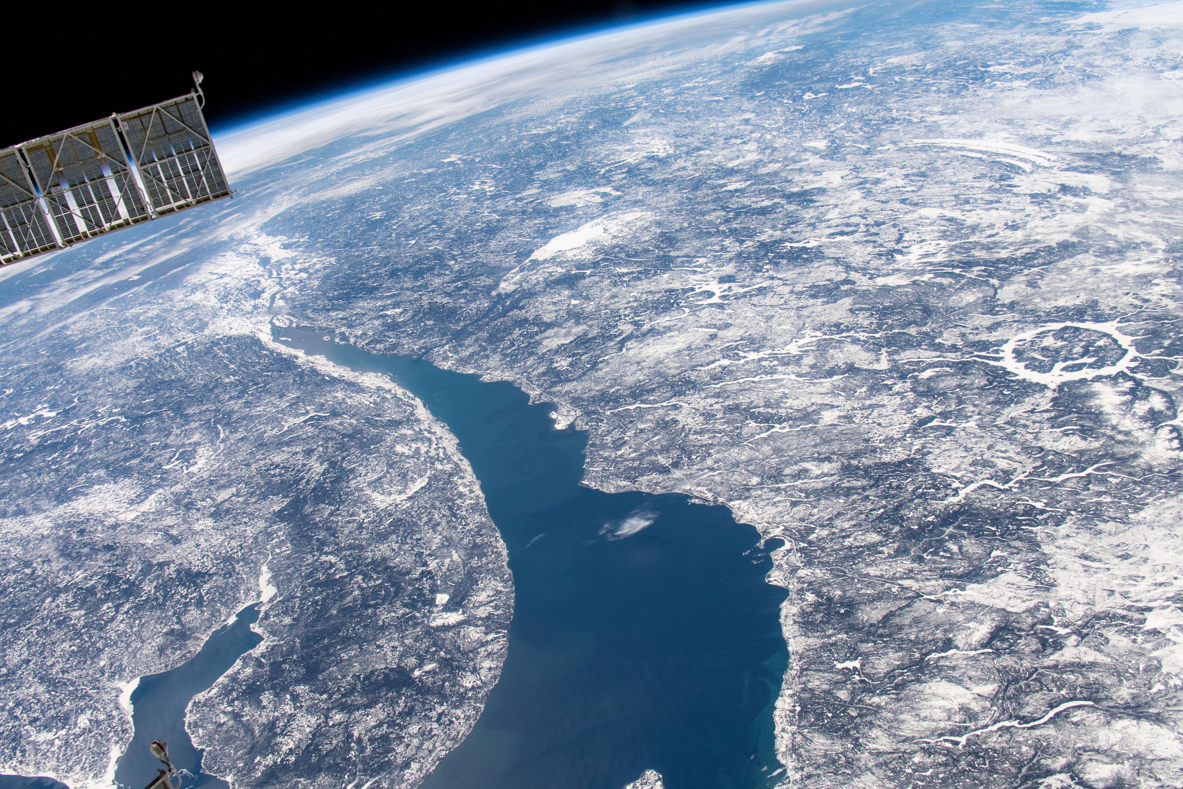 صورة للأرض من محطّة الفضاء الدوليّة يظهر فيها نهرٌ عريض في أسفل المُنتَصَف واليسار وفوّهة كبيرة مملوءَة بالماء إلى يمين المركز، كما يظهر جزءٌ من المحطّة في أعلى يسار الإطار.