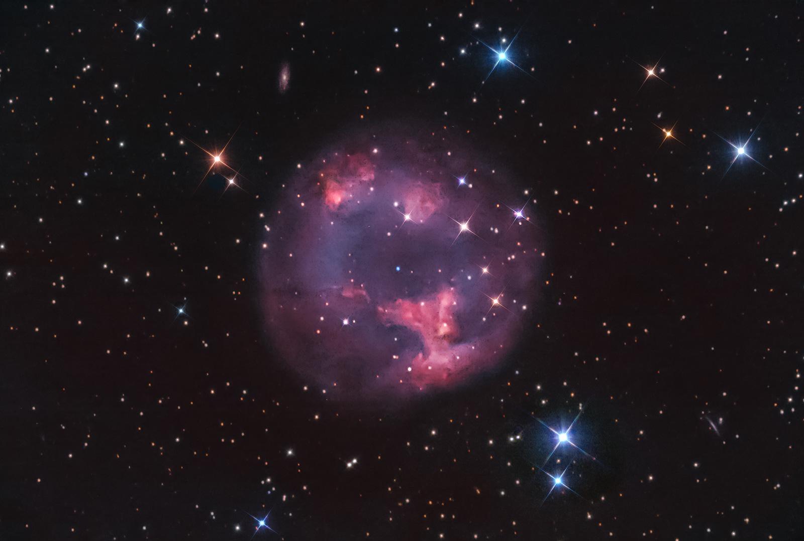 سديم كوكبي بطبقاته المنسلخة عن نجمه القزم الأبيض في المركز بينما تظهر نجوم مدبّبة وأخرى عادية على امتداد الصورة