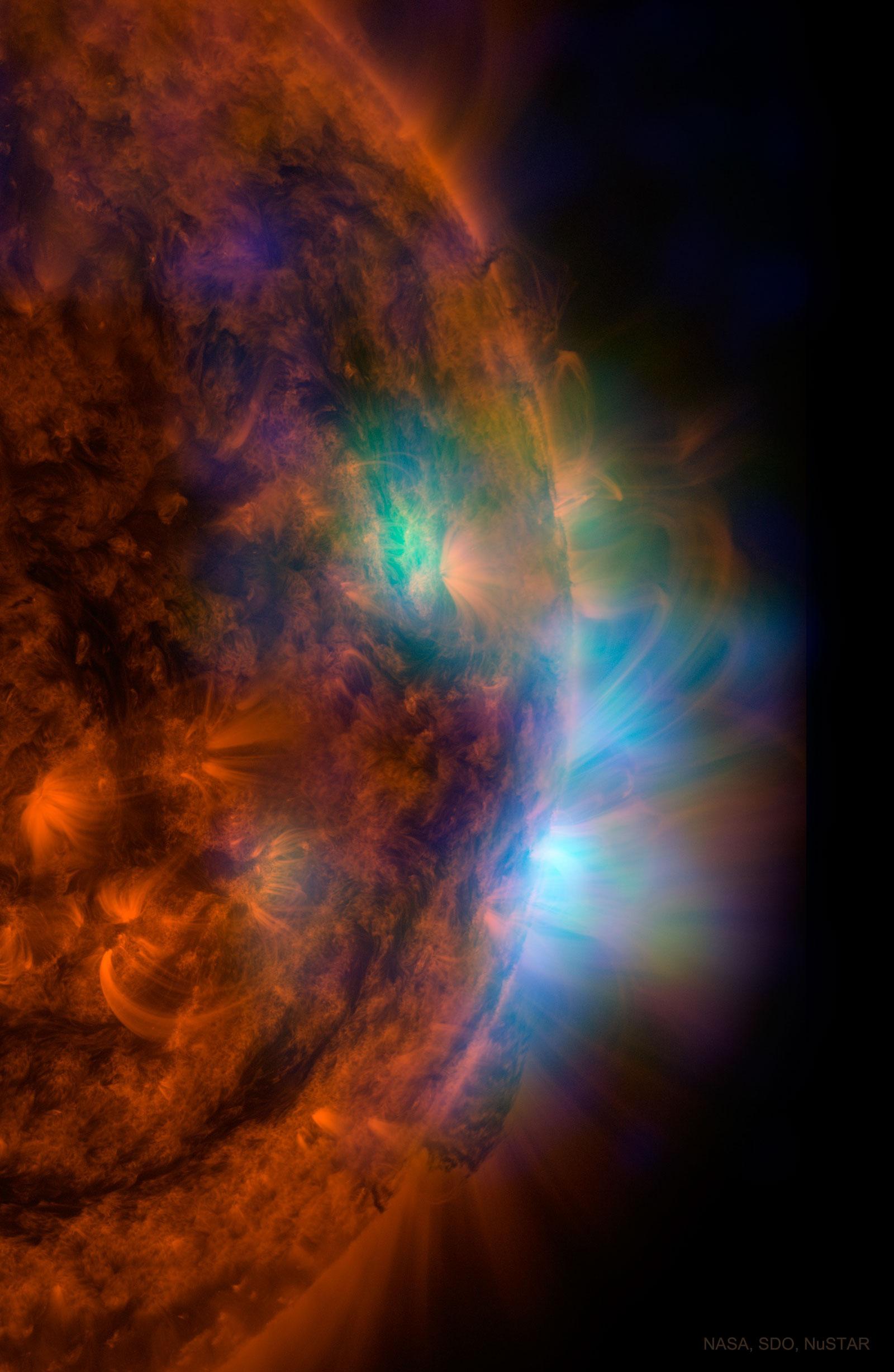جزء من قرص الشمس بالأشعة فوق البنفسجية مظهراً بعض المناطق بتدرجات اللون الأحمر، ومناطق أخرى ملتقطة بالأشعة السينيّة بألوان غير حقيقية تظهر تدفقات باللونين الأزرق والأخضر.