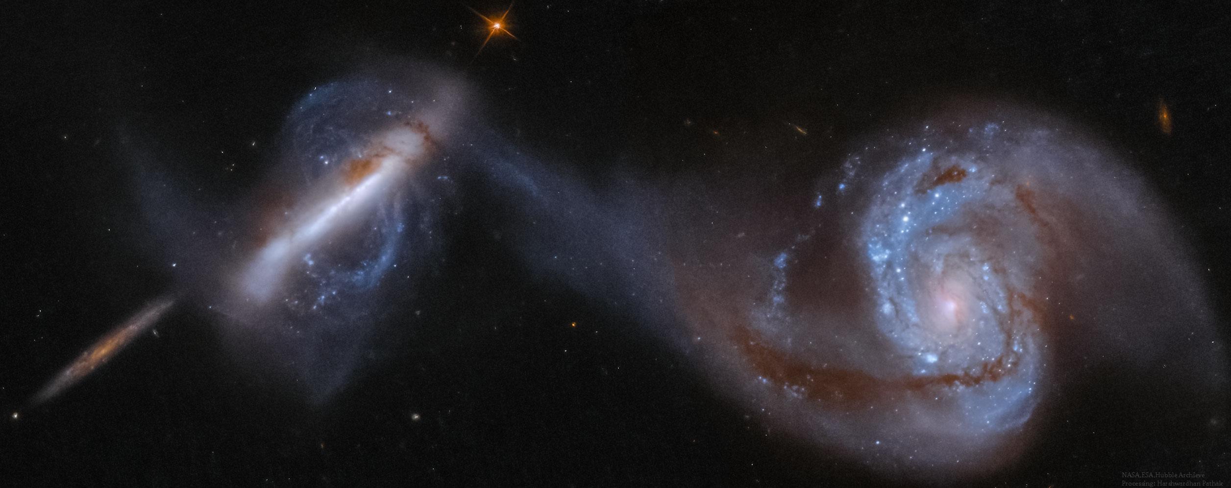 تظهر ثلاث مجرّات، اليُمنتان منهما في تصادم. المجرّة عند أقصى اليمين هي مجرّة حلزونيّة كبيرة مع ذراعٍ موصولة بمجرّة قطبيّة غير اعتياديّة يساراً. يُعتَقَد أنّ المجرّة الأصغر عند أقصى اليسار بعيدةً في الخلفيّة.