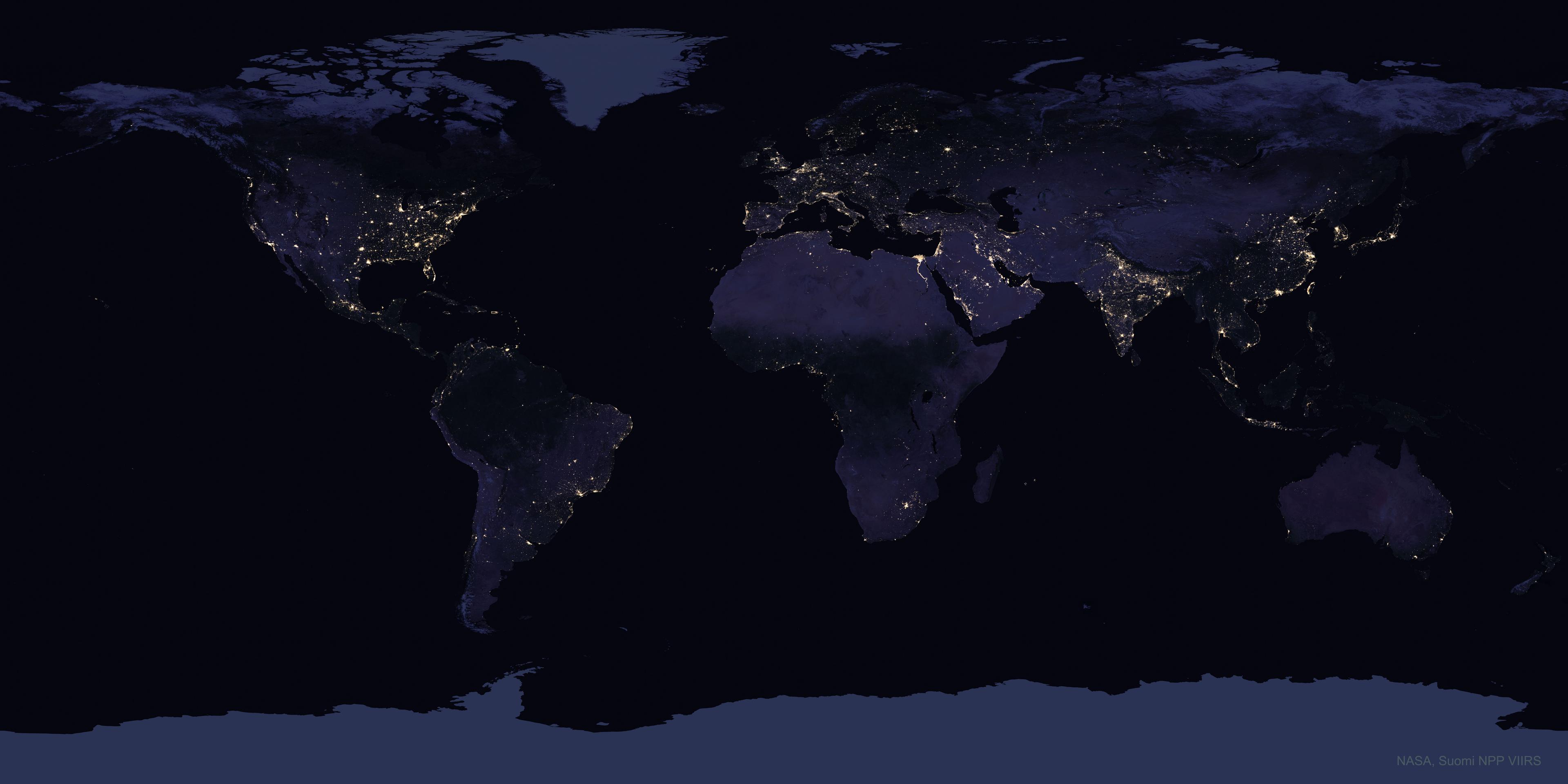 خريطة للأرض تظهر عليها القارّات والمحيطات في الليل حيث تشعّ أنوار المراكز الحضريّة