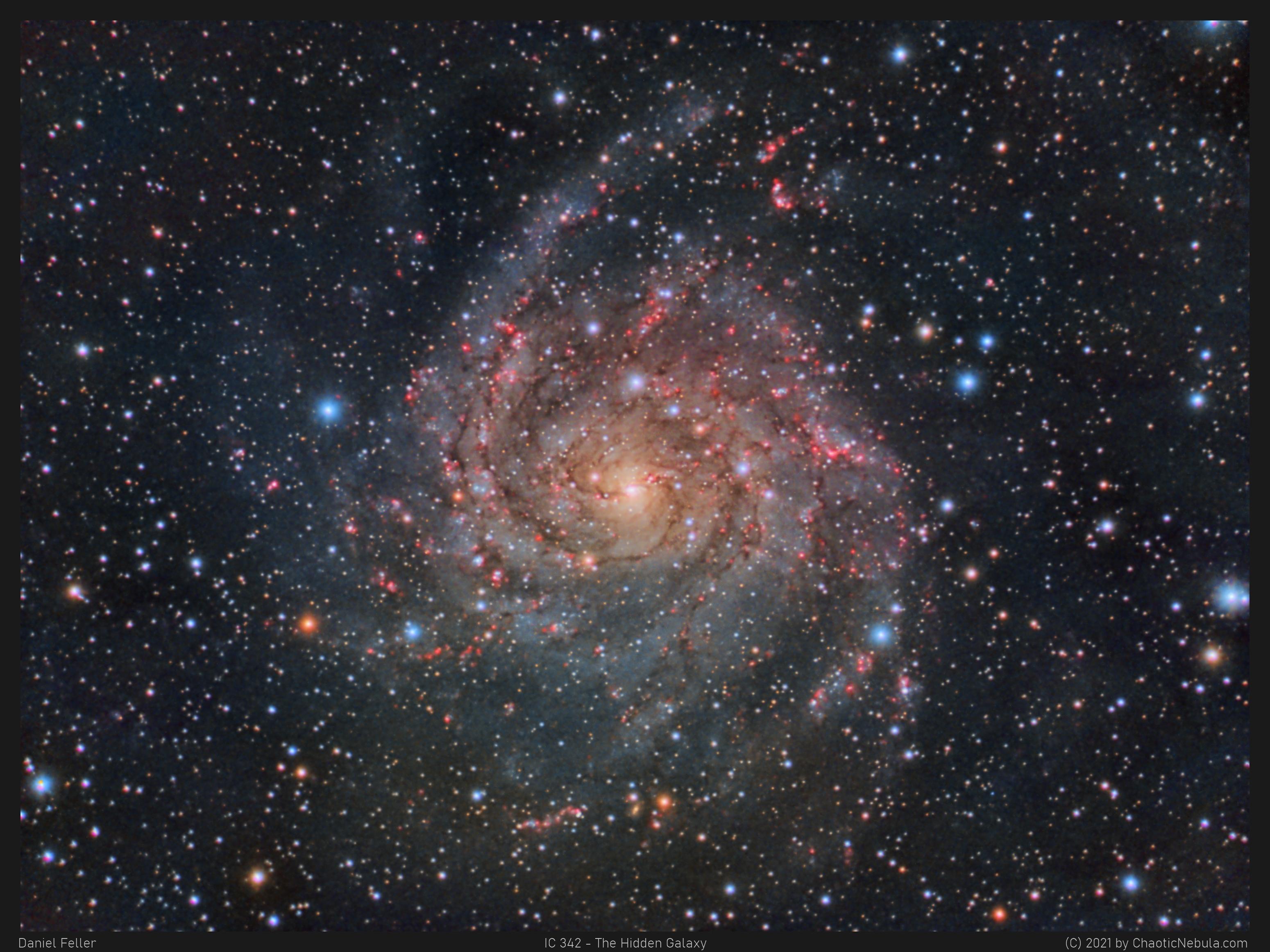 مجرّة حلزونيّة نراها من وجهها تظهر أذرعها الملتفّة المترامية وفيها مناطق التشكّل النجمي الورديّة. تظهر كذلك نجوم المقدّمة على امتداد الصورة