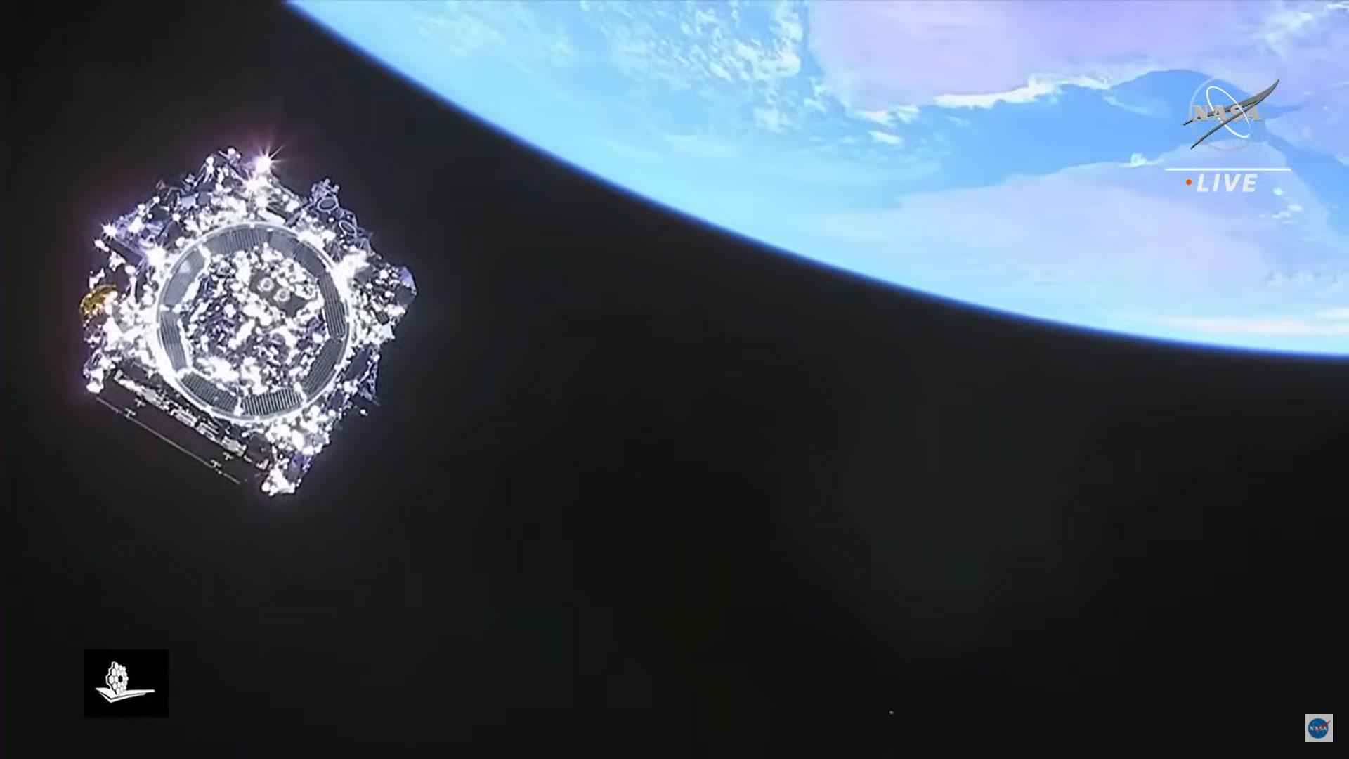 تلسكوب جيمس ويب يظهر كصندوق أدوات تنعكس عنه أشعّة الشمس وهو يسبح في الفضاء ومن تحته كوكب الأرض.