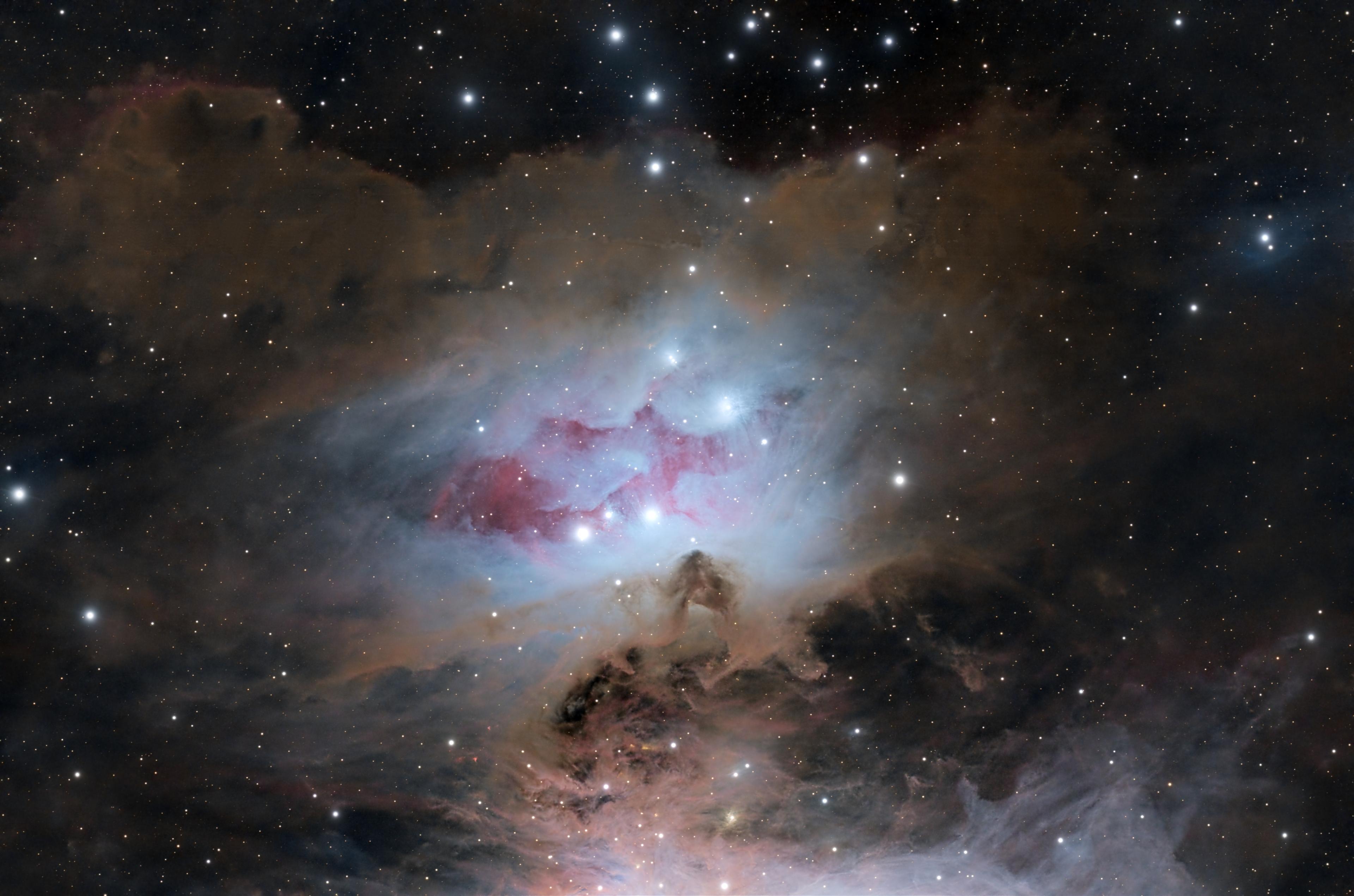 سديم انعكاسي يظهر بلون مزرقّ مع امتداد محمرّ داخله وانتشار غبار بينجمي حوله، مع تناثر النجوم عبر الصورة