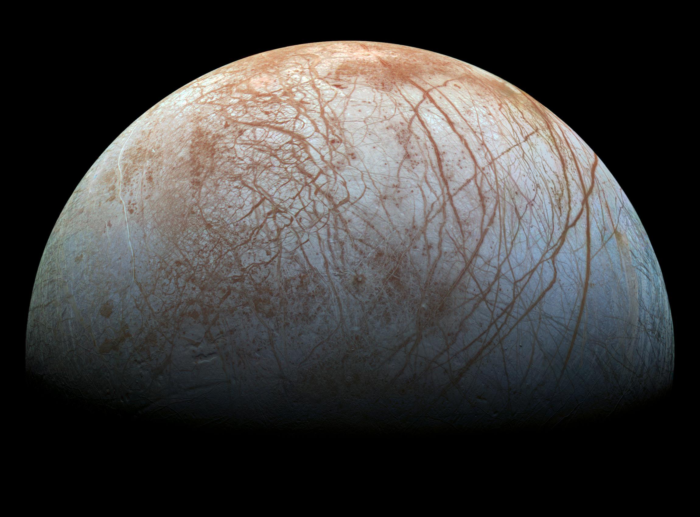 صورة محسّنة لنصف قمر المشتري گاليليو، يظهر فيها سطحه مخطط بصدوع طويلة منحنية محمرة.