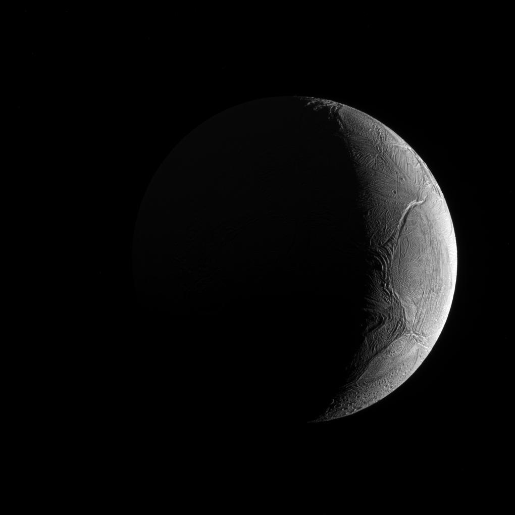 هلال قمر يبدو ككرة جليديّة عملاقة وعلى ما يبدو مسارات انزلاق مهولة وبعض الفوّهات الصدميّة
