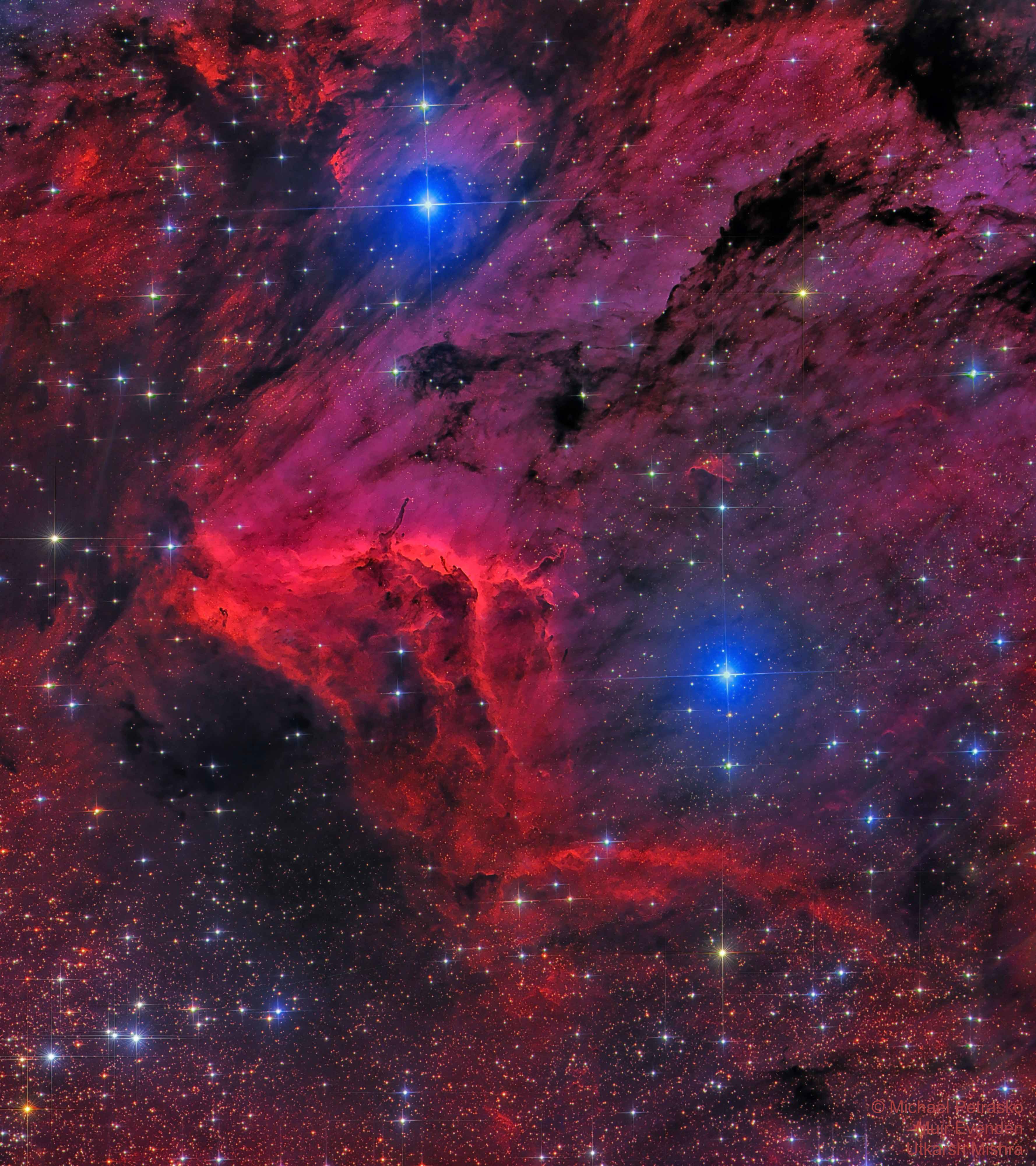 صورة لسديم البجعة تظهر فيها سحب الهيدروجين البينجميّ باللون الأحمر مع جبهة التأيّن في منتصف الصورة بلون أحمر فاقع، مع نجومٍ تظهر أكبرها بلونٍ أزرق.