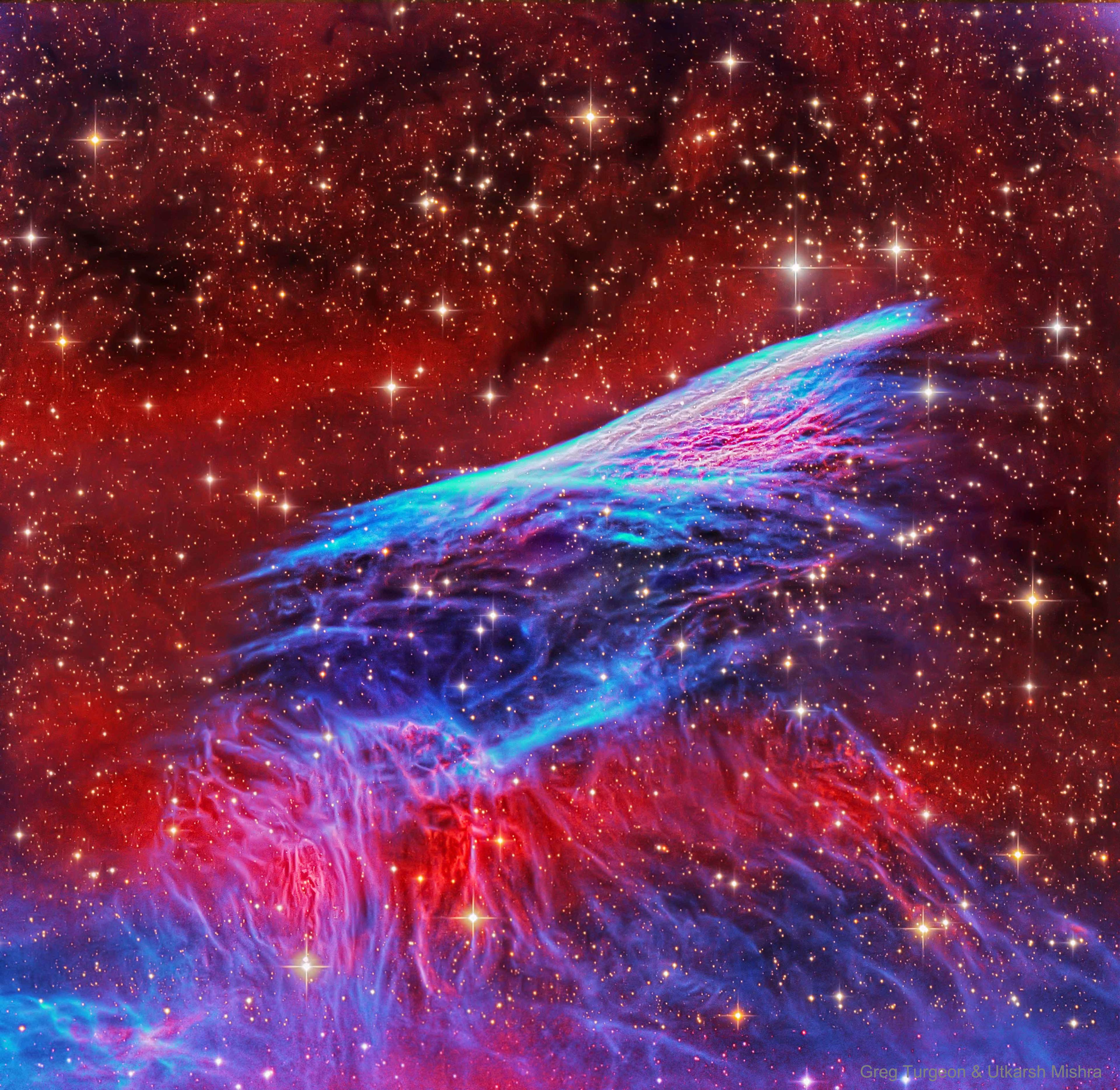 سديم بخيوط رفيعة ساطعة مجدولة متموّجة باللونين الأحمر والأزرق وما بينهما يظهر كاسطوانة شفافة في وسط الصورة وتحتها لهب، على خلفيّة كونيّة يسودها اللون الأحمر وتنتشر النجوم على امتداد الصورة.