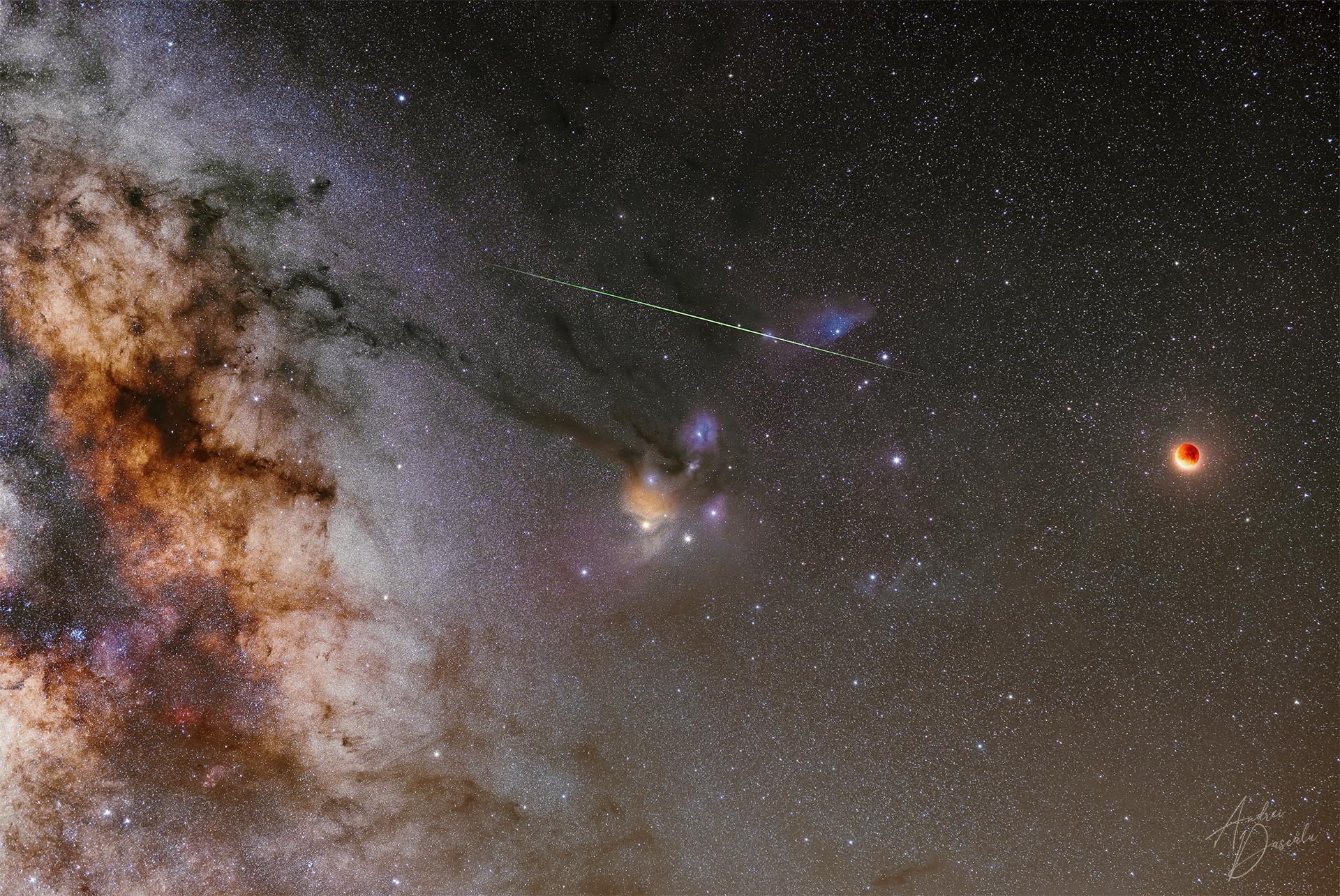 قمر مخسوف محمرّ على اليمين بينما يعبر شهاب أعلى وسط الصورة وتحته سديم فيه نجوم ساطعة وعلى اليسار النطاق المركزي لدرب التبّانة بينما تتناثر النجوم عبر الصورة
