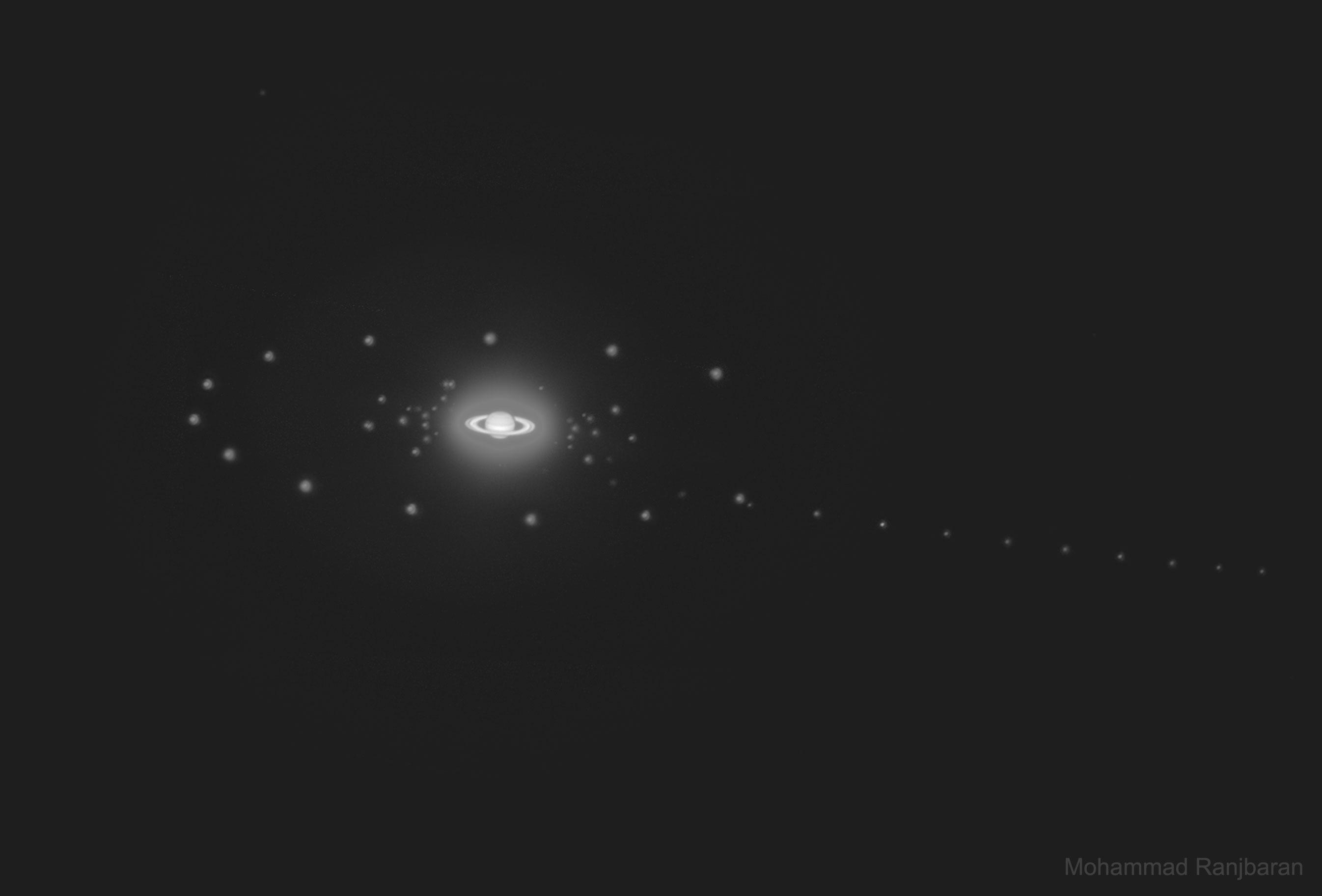 تُظهر الصورة كوكب زحل مع بعض من أقماره، التقطت بعدة تعريضات.