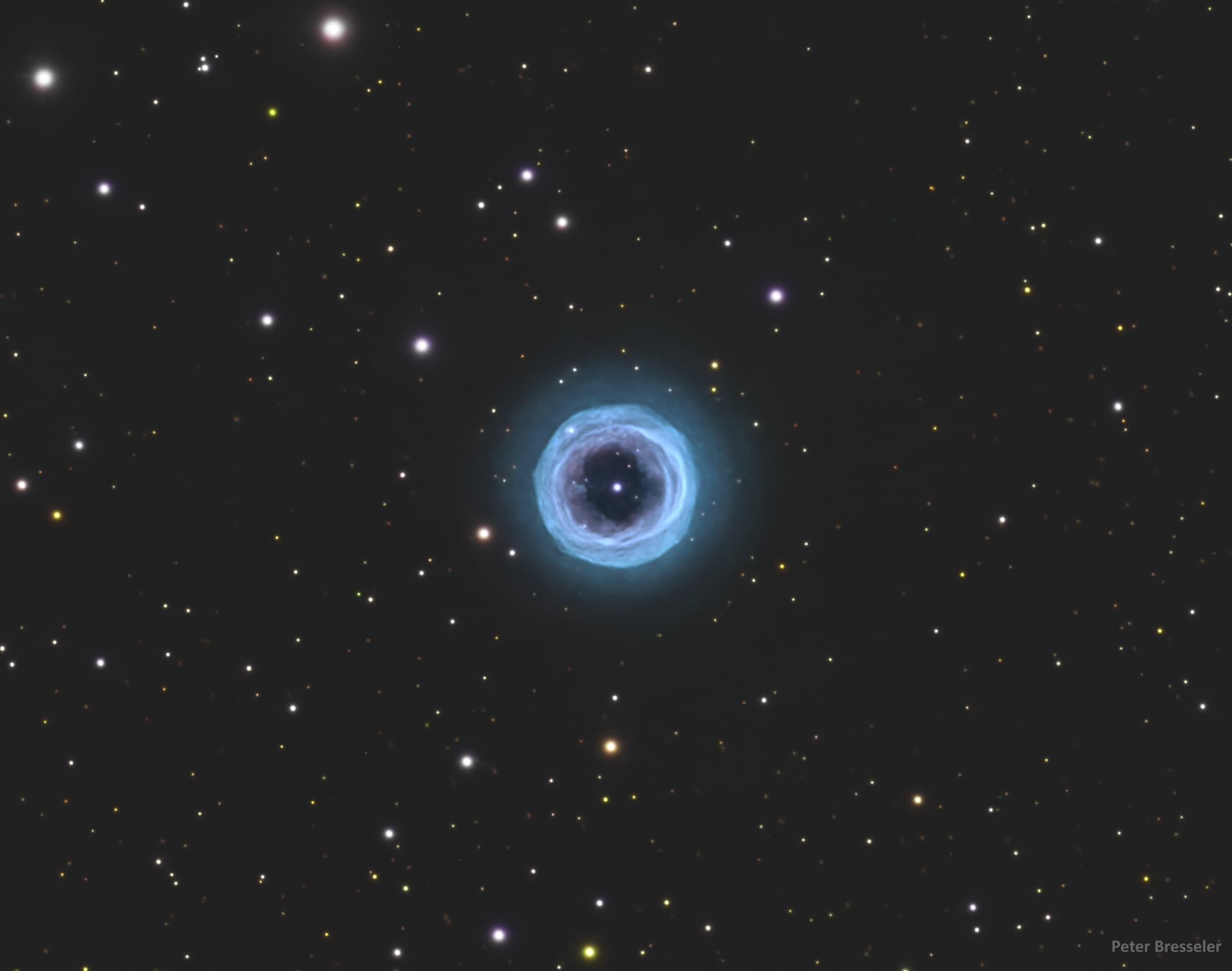 يظهر حقل نجميّ بحلقة زرقاء دائريّة كبيرة في المنتصف. في مركز الحلقة توجد بقعة زرقاء ساطعة.