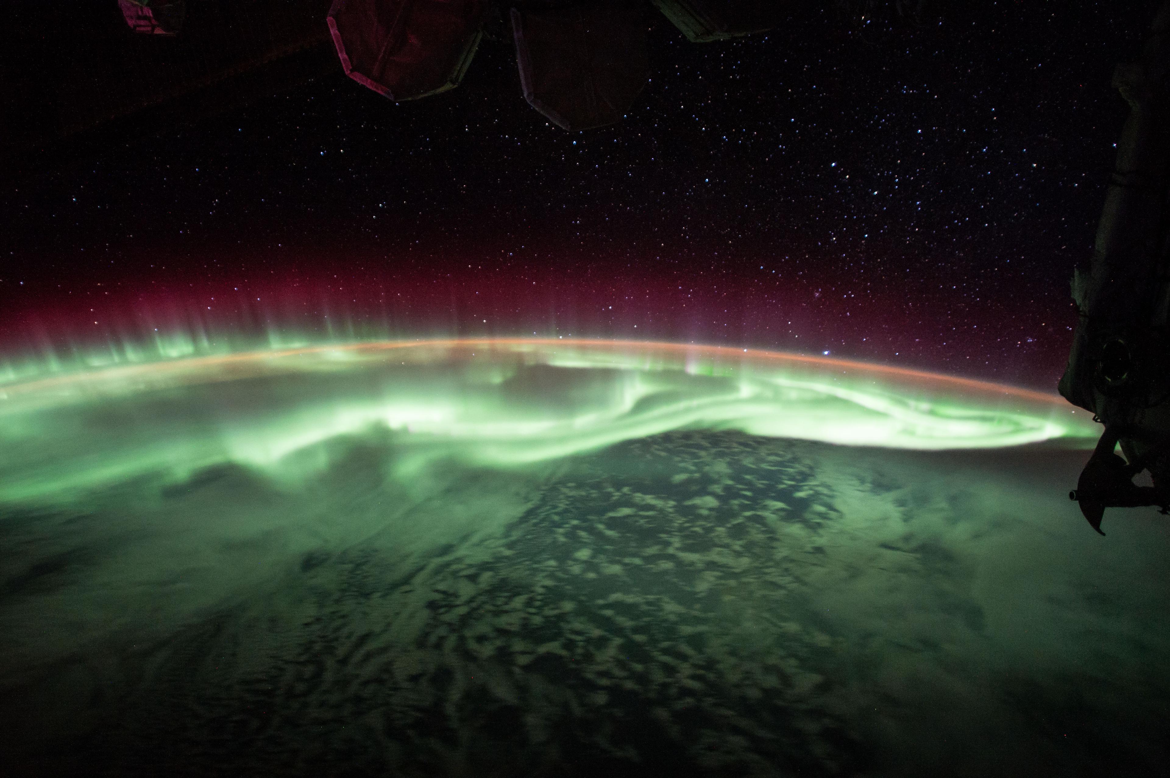 الشفق القطبي فوق الأرض كما التقط من محطة الفضاء الدولية حيث تظهر طبقاته الخضراء عند الارتفاعات المنخفضة وتلك المائلة إلى الأحمر في الارتفاعات الأعلى. الصورة التقطت أثناء مرور المحطّة فوق نقطة تقع إلى الجنوب الشرقي من أستراليا، مع ظهور نجوم أعلى يمين الأفق تنتمي إلى كوكبة الكلب الأكبر. تظهر كذلك الشعرى اليمانية كألمعِ نجمٍ بالقرب من طرف الأرض.