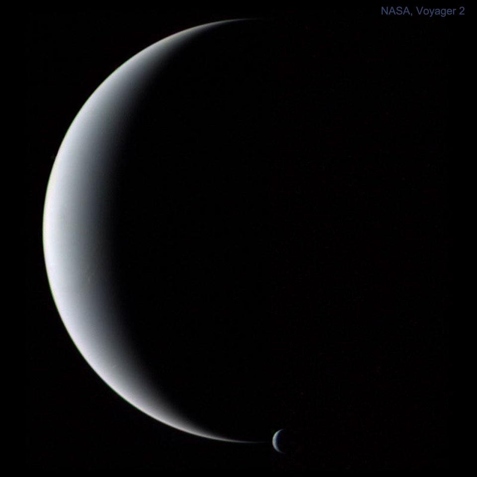 كوكب "نِپتون" وقمره "ترايتون"، كلاهما في طور الهلال، كما التُقِطا مِن قِبَل مركبة "ڤوياجر 2" الفضائيّة في 1989.