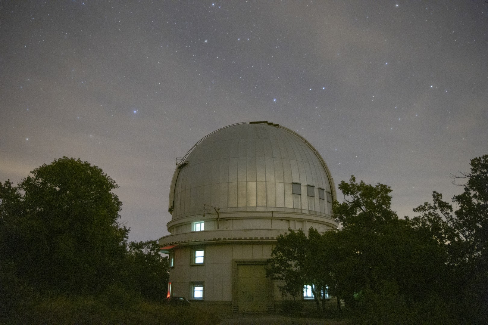 صورة لمبنى مرصد "أوت پروڤينس" في فرنسا مُلتَقَطة في ليلةٍ سديميّة مع ظهور النجوم الأكثر سطوعاً فوق قمة المرصد.