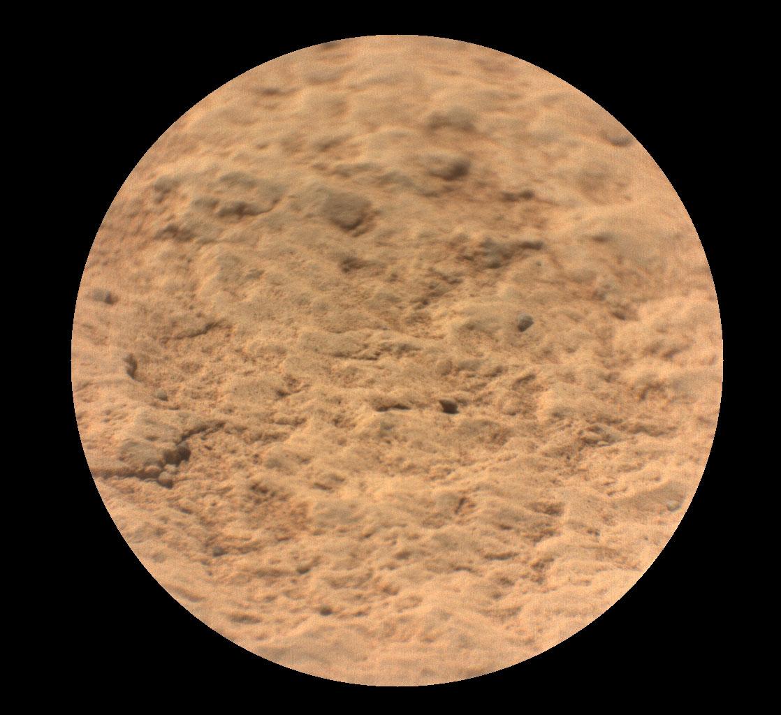 صورة دائريّة إطارها أسود يظهر داخلها تفاصيل مقرّبة لسطح صخرة ماز على المرّيخ، التي تظهر بتدرّجات البنّي والكمّوني.