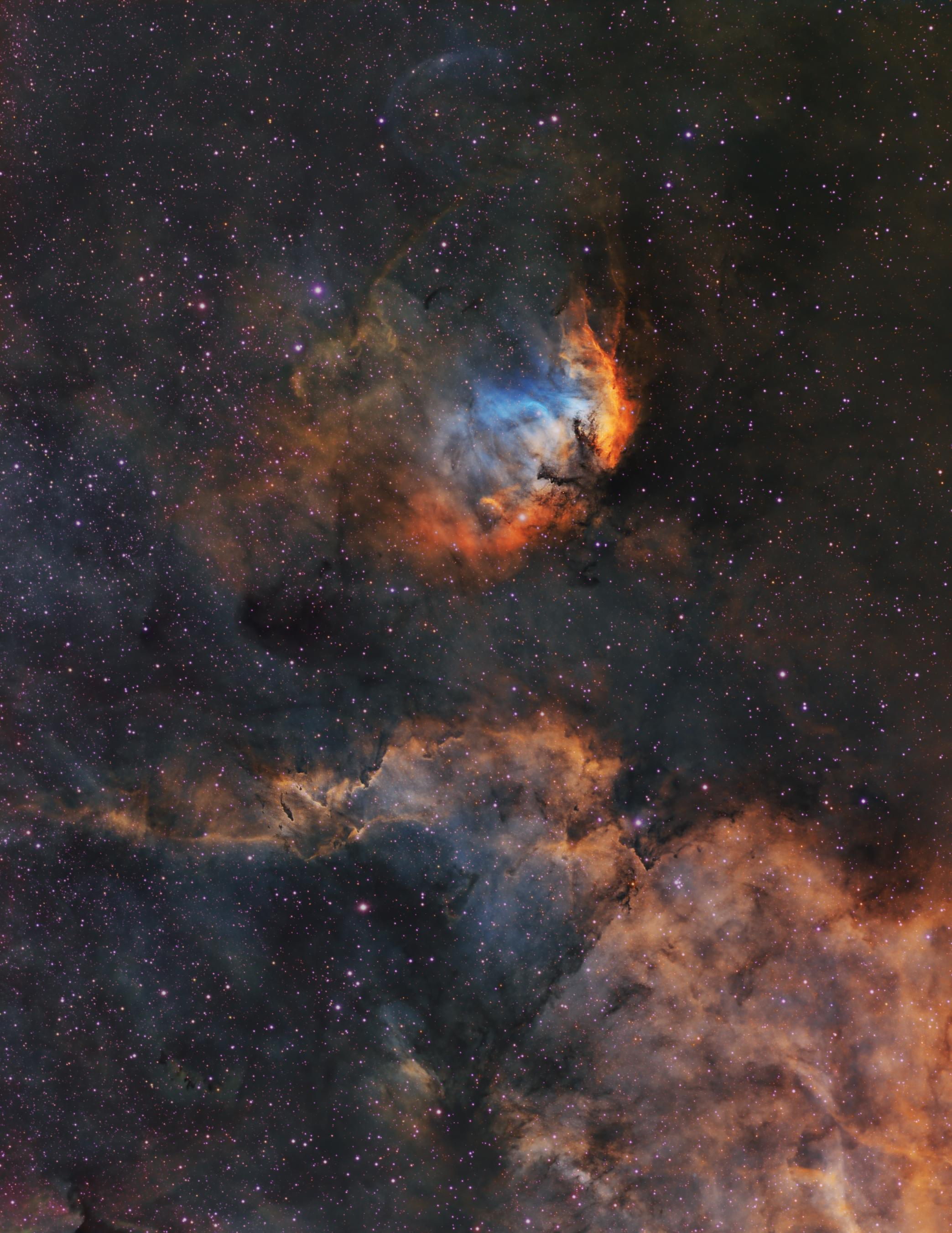 صورة للفضاء العميق بلوح ألوان هَبل تظهر سدماً وعازات وأعبرة بينجميّة، تتناثر النجوم عبر الصورة.