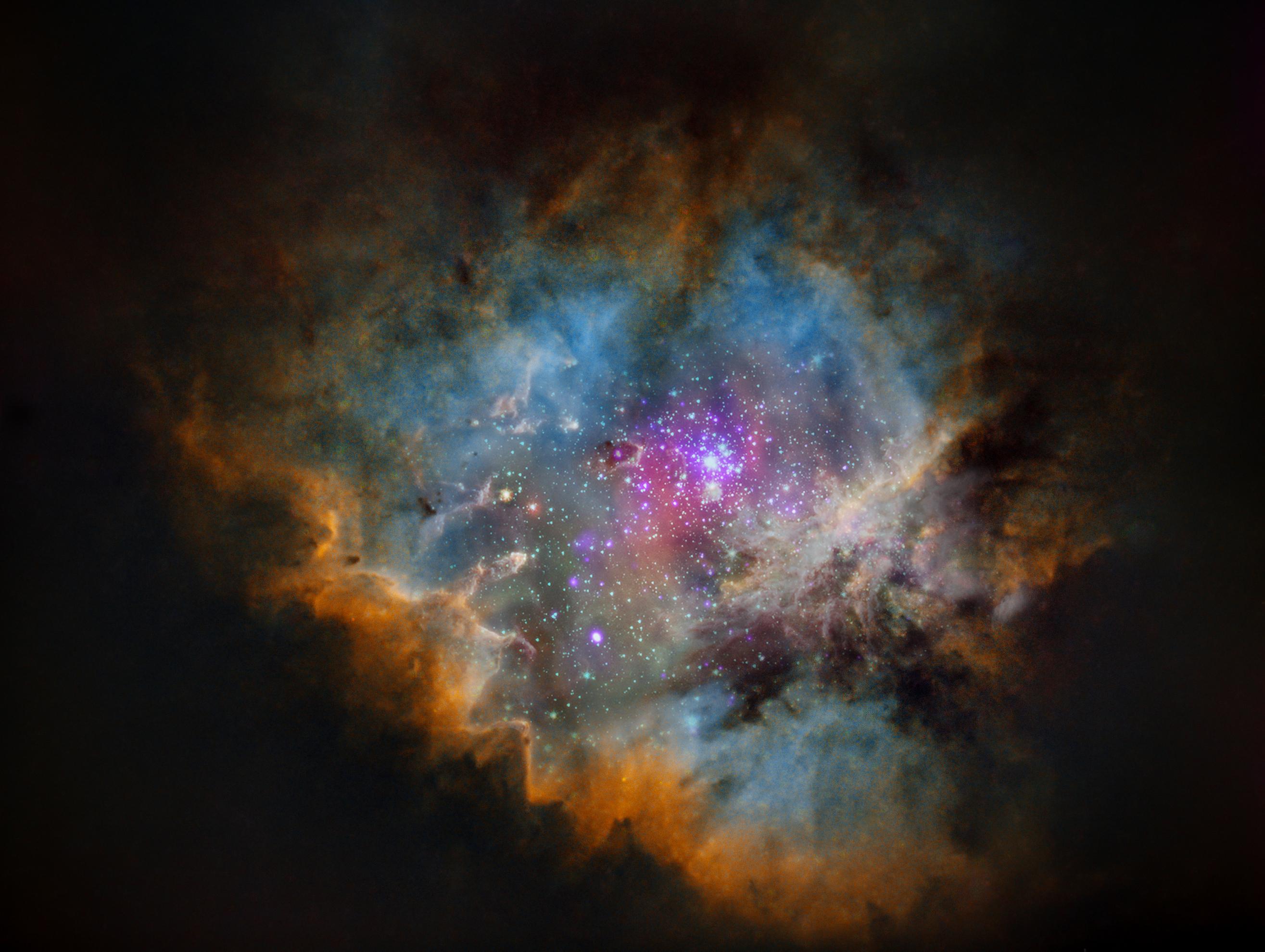 صورة معدلة رقمياً لسديم إن‌جي‌سي 281 الذي يتخذ شكل پاكمان والمحدد بسحب وأغبرة بألون بنية في الخارج فزرقاء، وفي مركزه تلمع نجوم العنقود النجمي آي‌سي 1590.